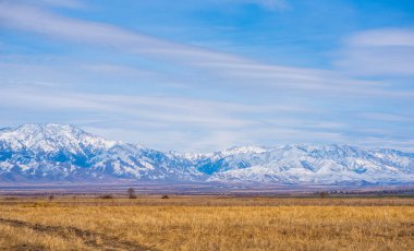 Panoramic view of the mountainside illuminated by the sun in the rocky mountains. The glow of the sun illuminates the autumn colors, along with the first snow found high in the mountain peaks.