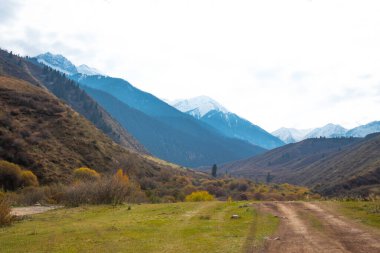 Panorama of a mountain landscape in northern China with snow-capped mountains. Foggy autumn day with first snow in Qitai county Xinjiang Uygur Autonomous Region, China.