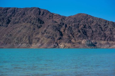 Yamdrok lake in the Tibet, China. Autumn landscape. Beautiful big blue lake on Highest land with mountains under blue sky and white clouds. Landmark of Tibet.