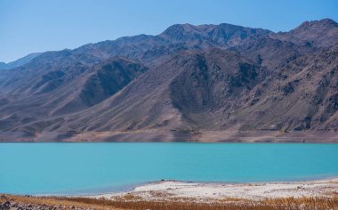 Yamdrok lake in the Tibet, China. Autumn landscape. Beautiful big blue lake on Highest land with mountains under blue sky and white clouds. Landmark of Tibet.