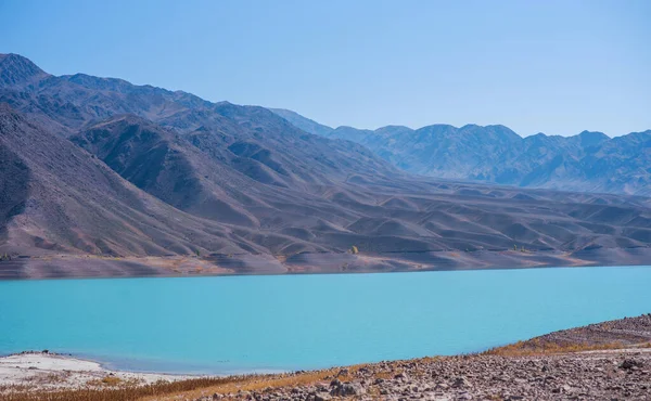 Yamdrok lake in the Tibet, China. Beautiful big blue lake on Highest land with mountains under blue sky and white clouds.Landmark of Tibet.