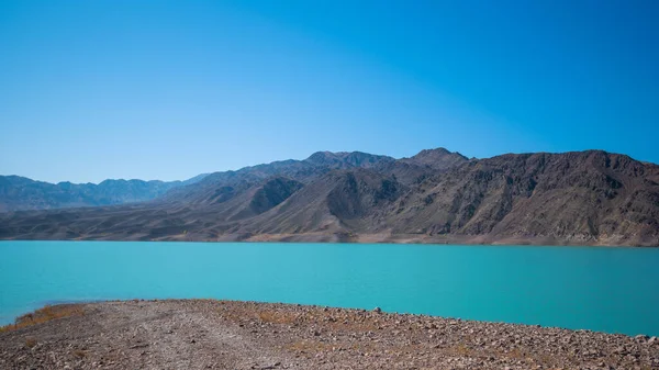 Yamdrok lake in the Tibet, China. Autumn landscape. Beautiful big blue lake on Highest land with mountains under blue sky and white clouds. Landmark of Tibet.