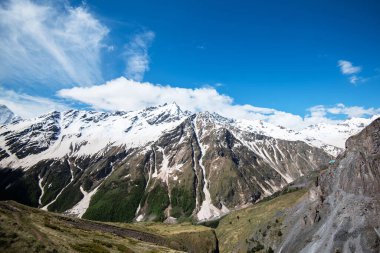 Mountain landscape. Caucasus mountains. Svaneti. Georgia. Panoramic view from the hill on mountains with hiking path against cloudy sky.
