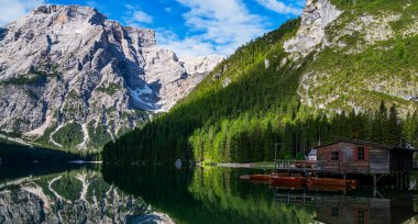 Braies Lake in Dolomites mountains forest on the background. The lake is surrounded by forest which are famous for scenic hiking trails. Mountain landscape, lake and mountain range.
