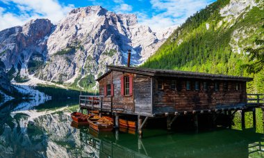 Braies Lake in Dolomites mountains forest on the background. The lake is surrounded by forest which are famous for scenic hiking trails. Mountain landscape, lake and mountain range.