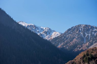 Panorama of a mountain landscape in northern China with snow-capped mountains. Foggy autumn day with first snow in Qitai county Xinjiang Uygur Autonomous Region, China.