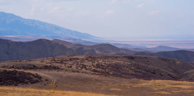 Bulutlu gökyüzü ile inanılmaz bir dağ manzarası. Güzel kırsal kesimin manzarası. Dağlarda harika bir sonbahar. Kuru çayır ve yuvarlanan tepeler. Doğal dış seyahat geçmişi. Güzellik dünyası.