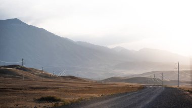 Görünür siluetlerle sabah sisinin arasında bir dağ silueti..