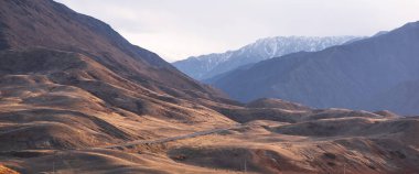 Dağlardan oluşan katmanlar, gölgeleri ve oluşumları ışıkla vurgulanmıştır. Uzak puslu dağlar, batan güneşin farklı gölgeleri..