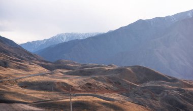 Dağlardan oluşan katmanlar, gölgeleri ve oluşumları ışıkla vurgulanmıştır. Uzak puslu dağlar, batan güneşin farklı gölgeleri..