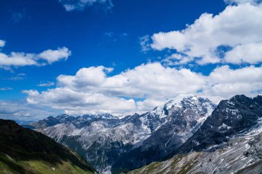 Alpler 'deki bulutlar, arka planda karla kaplı dağ tepeleriyle bulutların üzerinden geçiyor. Alp dağları, Fransız, İtalyan ve İsviçre Alpleri 'nin güzellikleriyle bezenmiş. Alpler' de kar örtüsüyle bulutların üzerinden geçen bulutlar.
