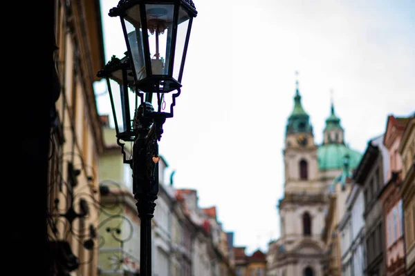 stock image Head of an old fashioned victorian style lamp post against an old buildings.