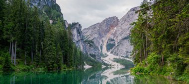 Dağ mavisi göl suyu manzarası. Dağların arkasında kristal suyu olan Braies Gölü. Dolomitler, İtalya.