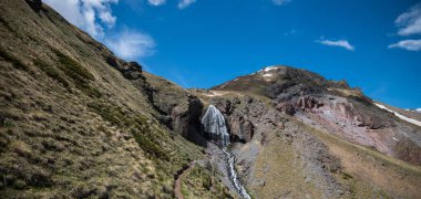 Mountain landscape. Caucasus mountains. Svaneti. Georgia. Panoramic view from the hill on mountains with hiking path against cloudy sky.