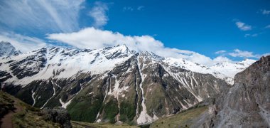 Mountain landscape. Caucasus mountains. Svaneti. Georgia. Panoramic view from the hill on mountains with hiking path against cloudy sky.