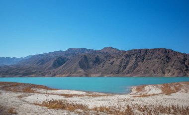 Dağlı manzara, mavi gökyüzü ve turkuaz suyu olan bir göl. Himalayalar 'da ıssız bir dağlık bölge..