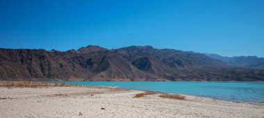 Dağlı manzara, mavi gökyüzü ve turkuaz suyu olan bir göl. Himalayalar 'da ıssız bir dağlık bölge..