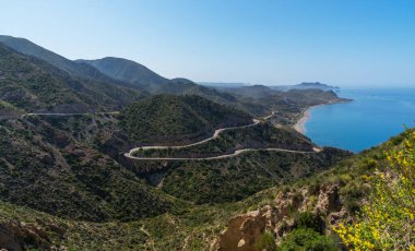İspanya 'nın doğu kıyısında dolambaçlı bir yol Murcia dağları, mavi deniz ve gemi, Costa del Sol. Dik kayalıkları olan deniz boyunca güzel bir yol. Mavi gökyüzü ve deniz manzarası.
