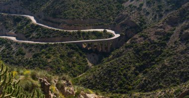 İspanya 'nın doğu kıyısında dolambaçlı bir yol Murcia dağları, mavi deniz ve gemi, Costa del Sol. Dik kayalıkları olan deniz boyunca güzel bir yol. Mavi gökyüzü ve deniz manzarası.