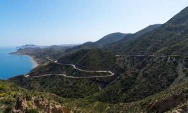 İspanya 'nın doğu kıyısında dolambaçlı bir yol Murcia dağları, mavi deniz ve gemi, Costa del Sol. Dik kayalıkları olan deniz boyunca güzel bir yol. Mavi gökyüzü ve deniz manzarası.