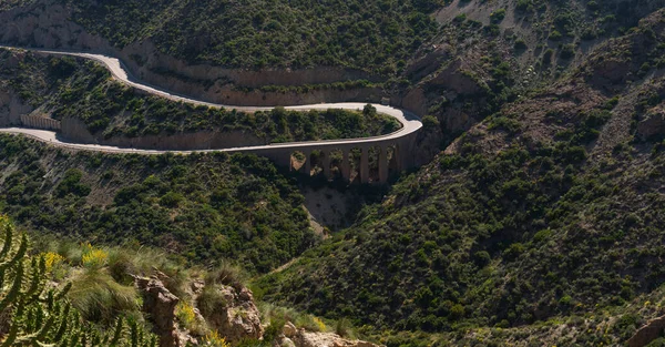 stock image A winding road on the east coast of Spain Murcia mountains, blue sea and ship, Costa del Sol. A beautiful road along the sea with steep cliffs. View of the blue sky and the sea.