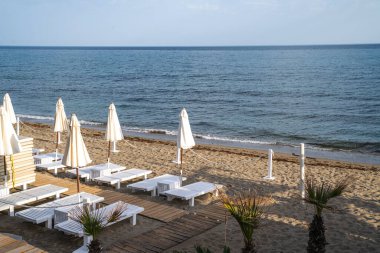 Plaj tatil beldesi, deniz yaz tatili konsepti. Şemsiyeli tahta güneşlikler. Plaj otelinde bir dizi güneşlik..