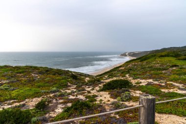 Nazare yakınlarındaki doğa manzaralı okyanus manzarası. Portekiz, plaja giden ahşap yol. Atlantik Okyanusu 'na bakan görkemli kıyı şeridi.