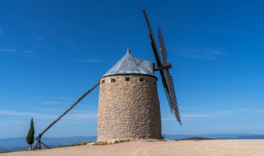 Tepedeki tipik eski İspanyol yel değirmenleri, İspanya 'nın yeşil manzarasıyla çevrilidir..