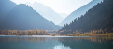 Güzel sonbahar manzaraları. Temiz suyla gölün göz kamaştırıcı sabah manzarası. Renkli sonbahar sahnesi. Doğanın güzelliği, konsept arka plan. Gölde ayna yansıması..