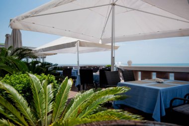 Açık terasta manzaralı bir restoran ya da kafe. Masalar mavi keten tabaklarla dolu. İtalyan tarzı. Turizm ve seyahat. Hayatın tadını çıkarıyorum. Güzel yerler..