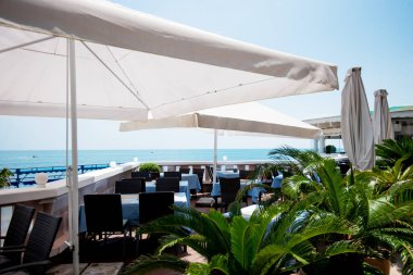 Açık terasta manzaralı bir restoran ya da kafe. Masalar mavi keten tabaklarla dolu. İtalyan tarzı. Turizm ve seyahat. Hayatın tadını çıkarıyorum. Güzel yerler..