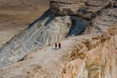 Issız çölde yürüyen bir grup gezgin, büyüleyici kum taşı oluşumlarıyla. İnanılmaz çöl manzarası. Çölde monolitik, tuhaf kumtaşı kayaları.