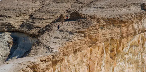 Stock image Walking group of travelers through the uninhabited desert, with stunning sandstone rock formations. Amazing desert landscape. Monolithic, bizarre sandstone rocks in the desert.