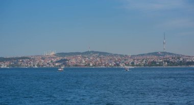 Mavi gökyüzüne ve bulutlara karşı Golden Horn körfezinde turistik gezi gemileri. İstanbul, Türkiye. Güneşli yaz gününde.