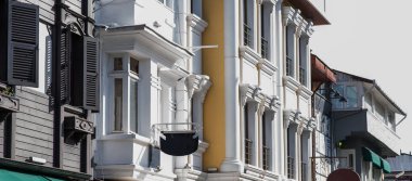 Geleneksel ahşap panjurlu eski ve yeni mimarinin aksine güneşli bir günde temiz çizgileri olan modern bir yapının yanında tarihi bir bina.