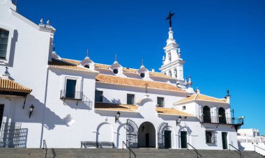 EL ROCO 'nun el değmemiş cephesi, zarif beyaz duvarları ve açık mavi gökyüzüne karşı duran süslü dini ayrıntılarıyla İspanyol güneşi altında parlıyor..