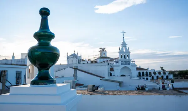 stock image a rooftop view in what appears to be a historic European town, showcasing traditional white architecture adorned with ornate bell towers and ceramic details, bathed in the soft glow of the setting sun