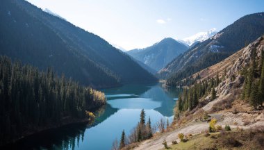 Bereketli kozalaklı ormanlarla dolu bir vadide, engebeli dağ yamaçlarında, berrak bir gökyüzünün altında. Sonbahar yaprakları bir tutam renk katar, yemyeşil ve karla dokunmuş zirvelere zıt.