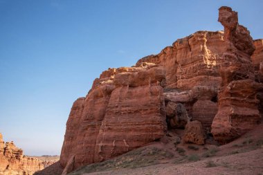 Yüksek kırmızı kumtaşı uçurumlarının ihtişamı berrak bir gökyüzüne karşı, durgun, el değmemiş bir çöl yaz sonlarında ya da sonbaharın başlarında sıcak aydınlatma nedeniyle.