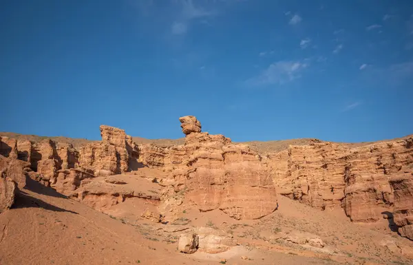 stock image a striking range of massive red sandstone formations under a vast blue sky, hinting at a tranquil desert setting in the warm, gentle light of a late summer afternoon