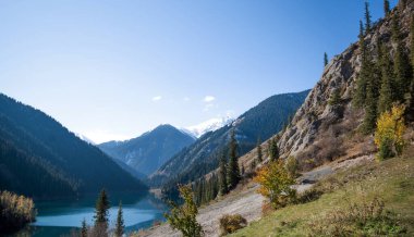 Durgun bir dağ gölü, bir vadiye yerleşmiş, sonsuz yeşillikle kaplı yamaçlar, berrak mavi gökyüzünün altında yükselen, doğanın ihtişamlı bir ahengi..