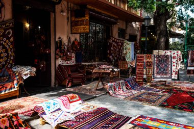 Cobblestone caddesinde renkli, karmaşık dokuma halıları ve tekstil ürünleri olan canlı bir market tezgahı. Geleneksel şablonlar, şehrin tarihi bir bölgesinde canlı bir atmosfer yaratıyor..