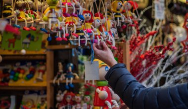 Alıcı, bebekler için çevre dostu plastiksiz oyuncaklar seçiyor. Bir çocuk için tahta oyuncak. Renkli. El sanatları. El yapımı..