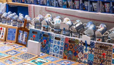 a selection of Portuguese ceramic souvenirs adorned with traditional patterns, presented in an outdoor market setting, in the historic city of Porto. clipart