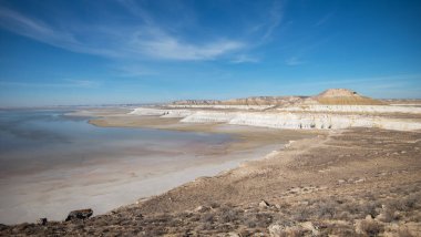 Sandy ovaları engin mavi gökyüzünün altında engebeli, beyaz kireçtaşı kayalıklarıyla buluşur. İnce su birikintileri uzak çöl manzarasının durgun ve el değmemiş güzelliğini yansıtır. Ufuk çizgisine uzanıp durur..