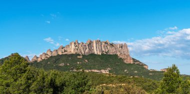 Ayırt edici kaya oluşumları, yemyeşil ormanlar ve açık mavi gökyüzü ile engebeli Montserrat sıradağlarının nefes kesici manzarası Katalonya manzarasının doğal güzelliğini gözler önüne seriyor..