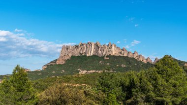 Ayırt edici kaya oluşumları, yemyeşil ormanlar ve açık mavi gökyüzü ile engebeli Montserrat sıradağlarının nefes kesici manzarası Katalonya manzarasının doğal güzelliğini gözler önüne seriyor..
