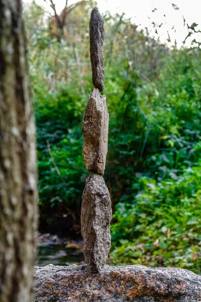 The photo of stone balancing. The stones feature intricate patterns and textures, delicately stacked on top of one another and appear to defy gravity