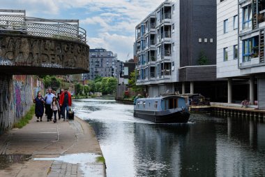 Londra - 06 03 2022: İnsanlar Rossendale Yolu yakınlarındaki Regent 's Canal Towpath' de yüzen evlerle yürüyor.
