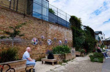 Londra - 06 03 2022: Şehir Yolu Havzası yakınlarındaki Regent Kanalı 'nda Crystal Hale' e adanmış bahçede oturan insanlar